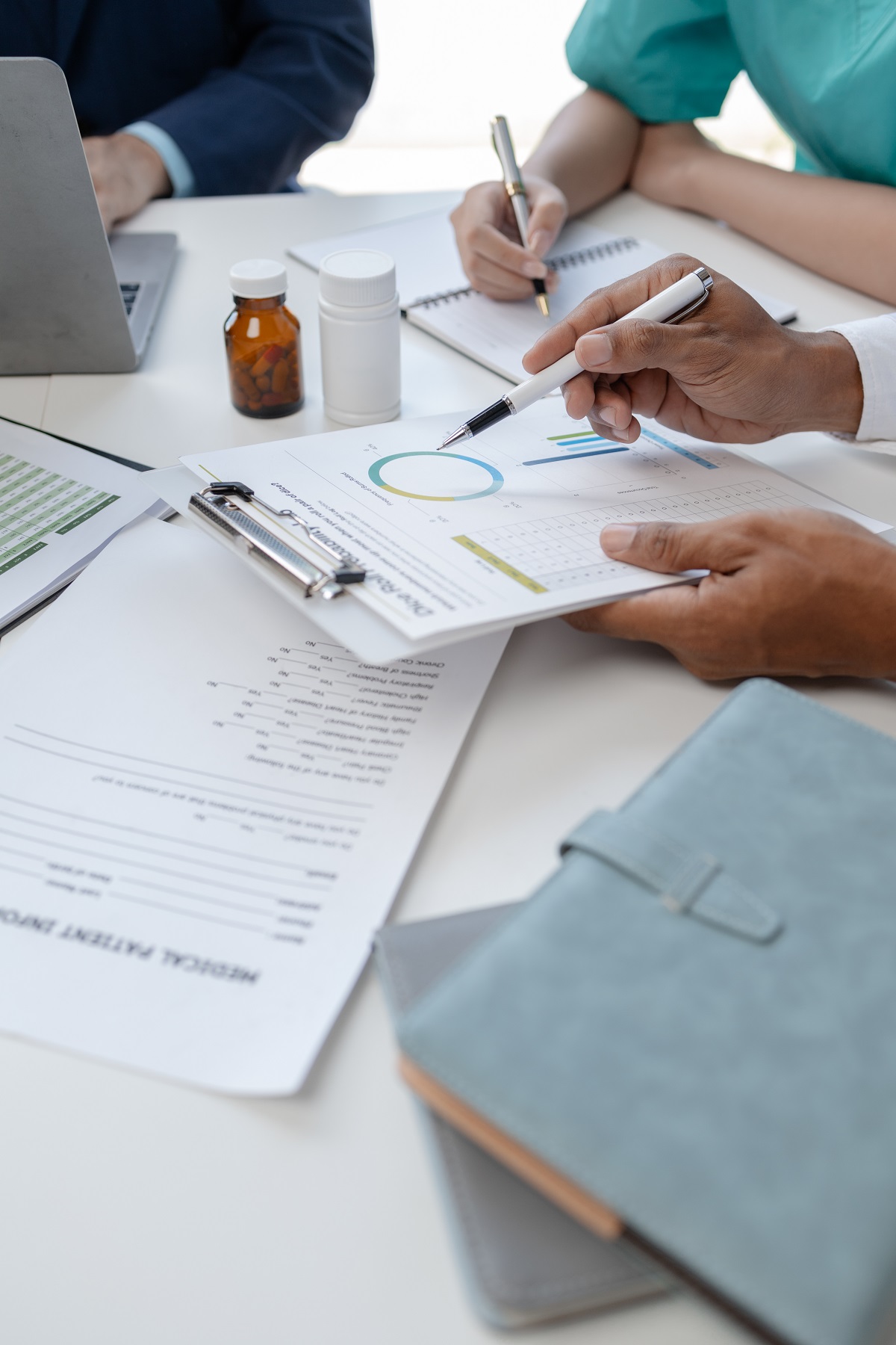 A team of medical cost consultants working together looking over documents