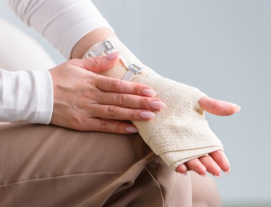 A close-up of an injured hand in a soft cast