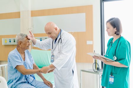 A doctor and nurse check on a patient