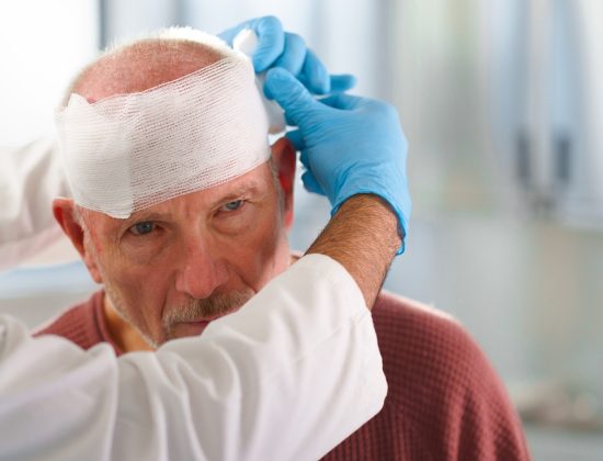 A man having his head wrapped by a medical professional after a head injury