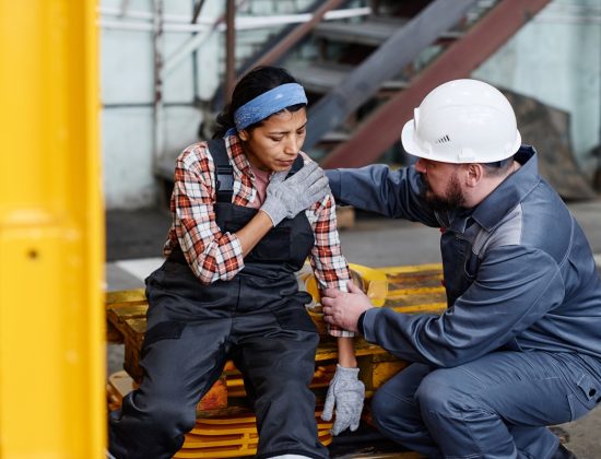 A worker helping another worker injured on the job